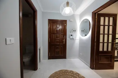 a hallway with a toilet and a wooden door at Apartamento acogedor centrico in Monforte de Lemos
