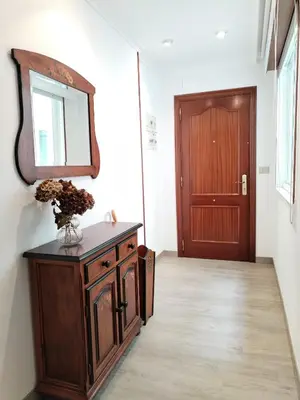 a hallway with a mirror and a cabinet and a door at Neboa in Viveiro