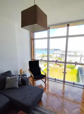 a living room with a couch and a large window at Neboa in Viveiro