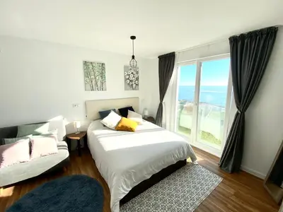 a bedroom with a bed and a large window at Apartamentos LAMAROSA -LAS PLAYAS in Burela de Cabo