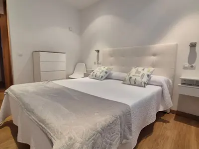 a white bedroom with a large white bed with pillows at Alojamiento en Ares a 2 minutos de la playa in Ares