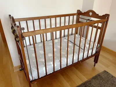 a crib in a room with a wooden floor at Dúplex Valle del Silencio in Ponferrada