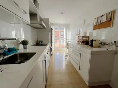 a white kitchen with a sink and white cabinets at Dúplex Valle del Silencio in Ponferrada