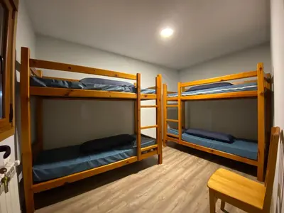 a room with three bunk beds in it at Albergue Pereiro in Melide