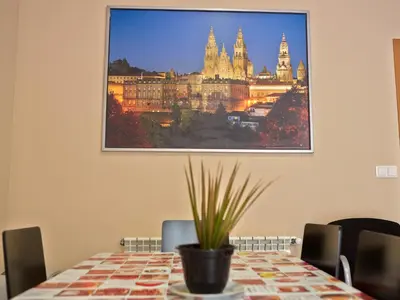 a painting hanging on a wall above a table at Albergue Pereiro in Melide