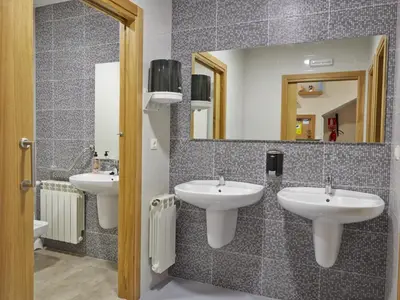 a bathroom with two sinks and a mirror at Albergue Pereiro in Melide