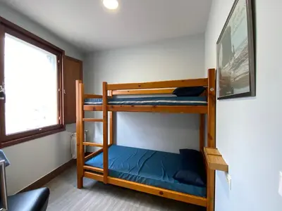 two bunk beds in a room with a window at Albergue Pereiro in Melide