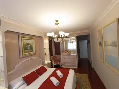 a bedroom with a bed with red and white pillows at Apartamento Plaza in Caldas de Reis