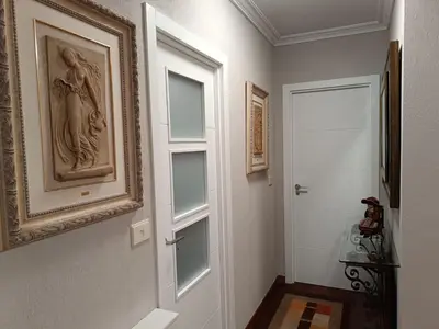 a hallway with a door and a painting on the wall at Apartamento Plaza in Caldas de Reis