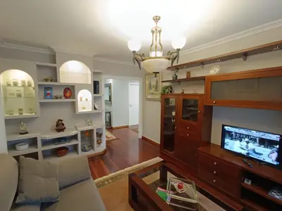 a living room with a large entertainment center and a tv at Apartamento Plaza in Caldas de Reis