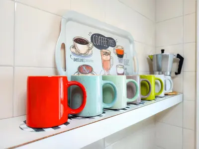 a row of coffee mugs sitting on a shelf at Apartamento Pena Furada in Ribadeo