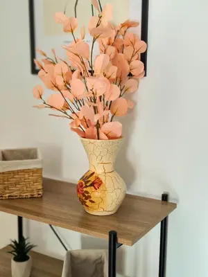 a vase with pink flowers sitting on a table at Apartamento Pena Furada in Ribadeo