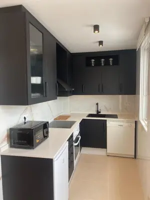 a kitchen with black cabinets and a microwave at Terraza as Travesas in Betanzos
