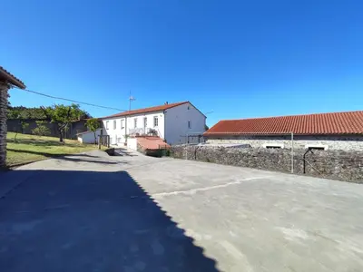 an empty road in front of a white building at CASA DAVID-con cuadras para caballos in Arzúa