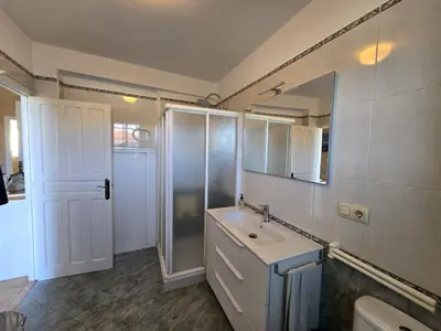 a bathroom with a sink and a mirror and a shower at CASA DAVID-con cuadras para caballos in Arzúa