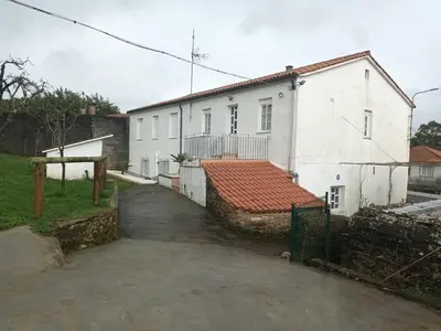a white house with a red tile roof at CASA DAVID-con cuadras para caballos in Arzúa