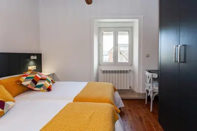 a bedroom with a large bed and a window at Casa do Cesteiro in Santiago de Compostela