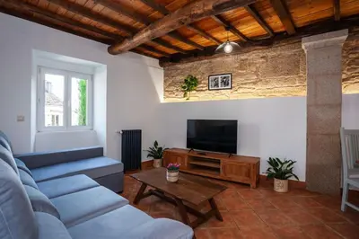 a living room with a blue couch and a tv at Casa do Cesteiro in Santiago de Compostela