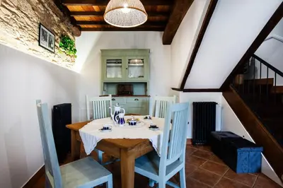a dining room with a table and blue chairs at Casa do Cesteiro in Santiago de Compostela