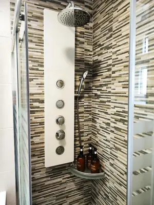 a shower in a bathroom with a tile wall at Alojamiento en Santiago de Compostela-Galicia in Santiago de Compostela
