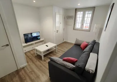 a living room with a couch and a tv at Alojamiento en Santiago de Compostela-Galicia in Santiago de Compostela