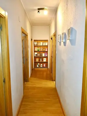 a hallway of an apartment with wooden floors and white walls at Segundo Antolín Yellow Door in Ponferrada