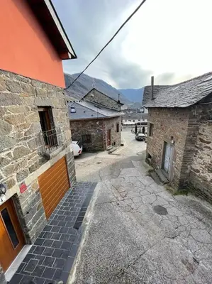 a stone building with a stairway leading to a street at Villaduranchi in Villablino