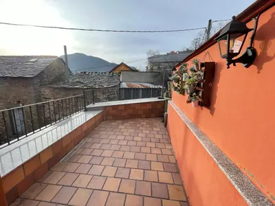 a balcony with an orange wall and some plants at Villaduranchi in Villablino
