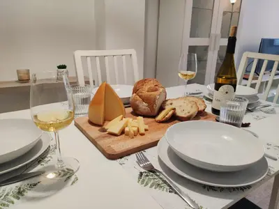 a table with cheese and bread and glasses of wine at O Soño de Santiago - Casa rural Mondoñedo, Galicia in Mondoñedo