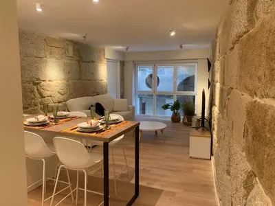 a kitchen and living room with a table and chairs at LAS TERRAZAS II Apartamento de lujo frente a la Catedral in Ourense