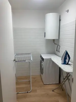 a laundry room with a washing machine and a table at LAS TERRAZAS II Apartamento de lujo frente a la Catedral in Ourense