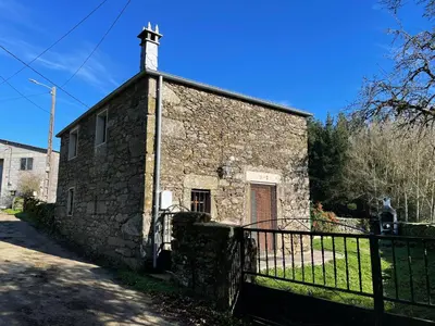 an old stone building with a cross on top at CASA GUIMARAS in Cortes