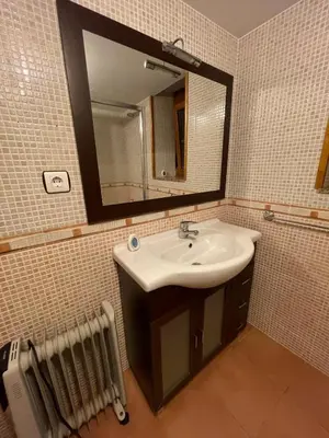 a bathroom with a sink and a mirror and radiator at CASA GUIMARAS in Cortes