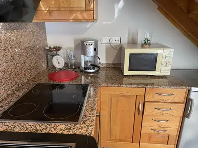 a kitchen with a microwave and a stove top oven at CASA GUIMARAS in Cortes