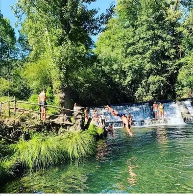 a group of people swimming in a river at El Rincón de la Mimosa in Vega de Espinareda