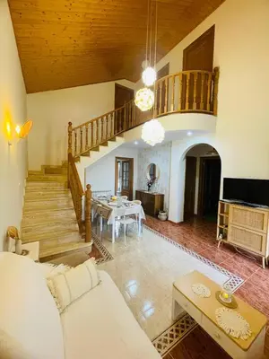 a living room with a staircase and a table at El Rincón de la Mimosa in Vega de Espinareda