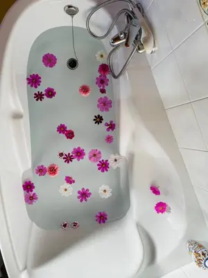 a white bath tub with pink flowers on it at El Rincón de la Mimosa in Vega de Espinareda
