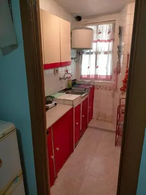 a small kitchen with red cabinets and a window at Apartamento Casco Viejo in Ourense