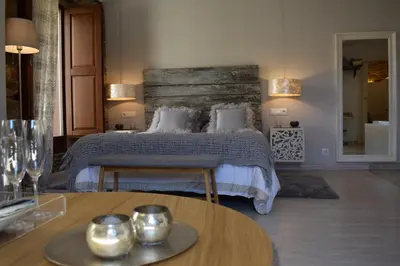 a bedroom with a bed and a table with candles at Casas de Outeiro in Samos