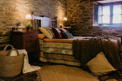 a bedroom with a bed and a brick wall at Casas de Outeiro in Samos