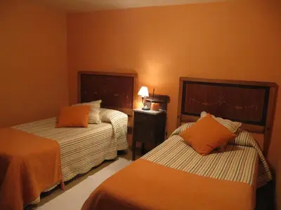 a hotel room with two beds with orange pillows at Casas de Outeiro in Samos