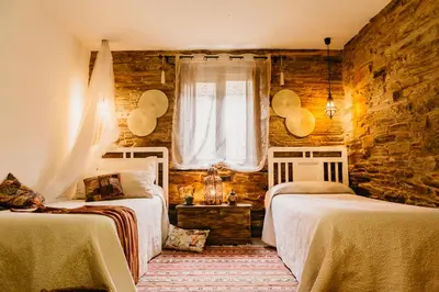 a bedroom with two beds and a window at Casas de Outeiro in Samos