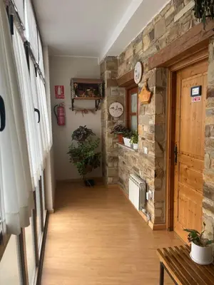 a hallway with a stone wall and a wooden door at Hotel Rural El Molinero de Santa Colomba de Somoza in Santa Colomba de Somoza