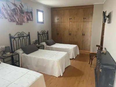 a room with two beds and wooden cabinets at Hotel Rural El Molinero de Santa Colomba de Somoza in Santa Colomba de Somoza