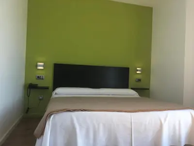 a bed in a room with a green wall at NRuta Ponferrada in Bembibre