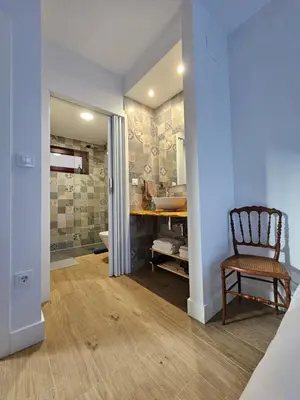 a bathroom with a sink and a chair in a room at La Cochorla in Páramo del Sil