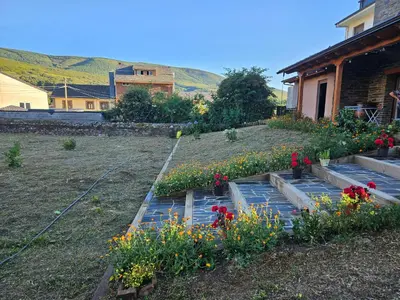 a garden with flowers in a yard next to a house at La Cochorla in Páramo del Sil