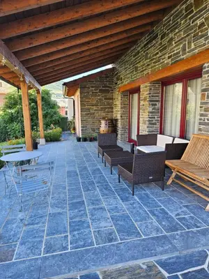 a patio with chairs and tables and a brick wall at La Cochorla in Páramo del Sil