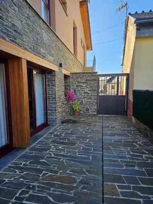 a stone walkway in front of a building at La Cochorla in Páramo del Sil