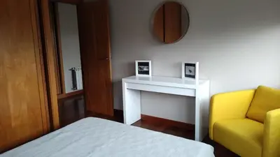 a bedroom with a bed and a yellow chair at Wanderlust Bastiagueiro in Perillo